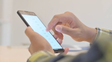 Close up of Young African Man Browsing Smartphone