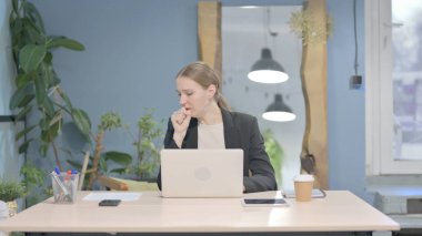 Young Businesswoman Coughing while Working on Laptop