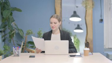 Young Businesswoman Working on Laptop and Documents