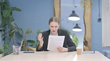 Young Businesswoman Feeling Upset after Reading Documents, Paperwork