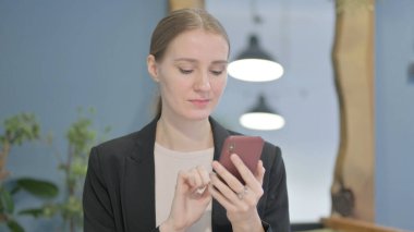 Young Businesswoman using Smartphone for Browsing Internet