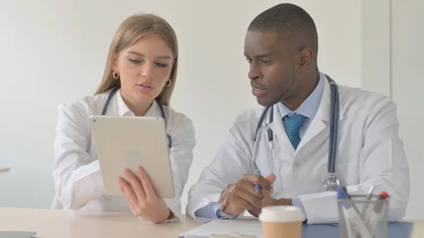 African-American Doctor and Female Doctor Checking Patient Medical Report