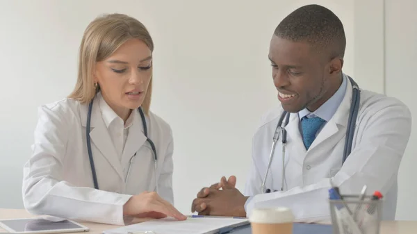 Female Doctor and African-American Doctor Working in Clinic
