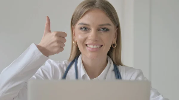 Thumbs Up by Lady Doctor Using Laptop in Clinic