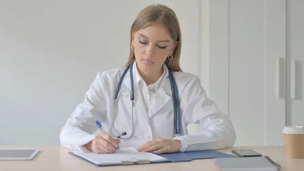 Close Up of Lady Doctor Writing Medical report