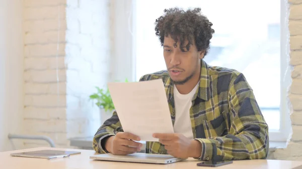 Tense Young African Man Feeling Upset after Reading Documents