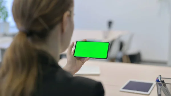 Young Businesswoman Holding Horizontal Smartphone with Green Screen
