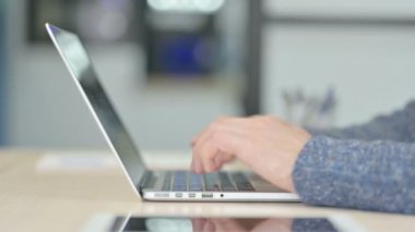 Side View of Male Hands Typing on Laptop