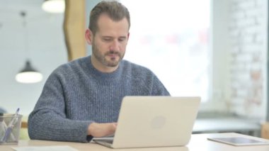 Mature Adult Man Typing on Laptop in Office