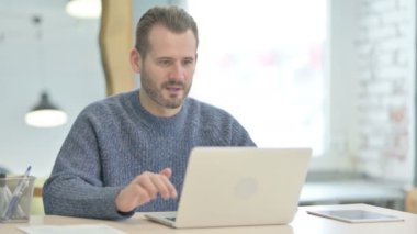 Mature Adult Man Celebrating Online Success on Laptop in Office