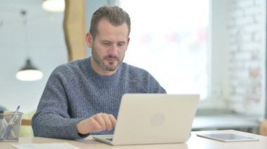 Mature Adult Man Reacting to Loss While Working in Office