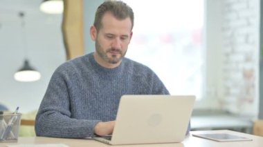 Thumbs Down by Mature Adult Man Working on Laptop