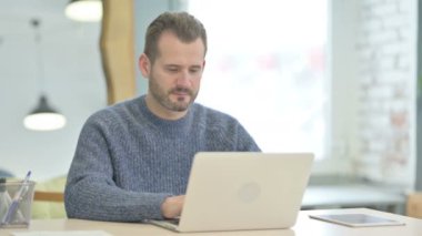 Mature Adult Man Shaking Head in Rejection while Working on Laptop