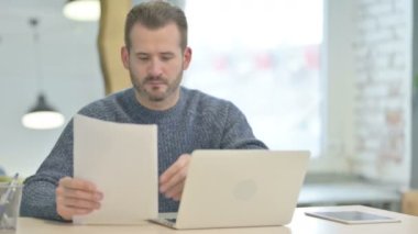 Mature Adult Man Working on Laptop and Documents