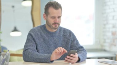 Successful Mature Adult Man Celebrating Win on Smartphone