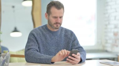 Upset Mature Adult Man Reacting to Loss on Smartphone