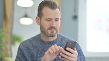 Mature Adult Man Celebrating Win on Smartphone