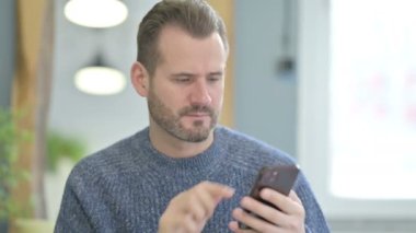 Shocked Mature Adult Man Facing Loss on Smartphone