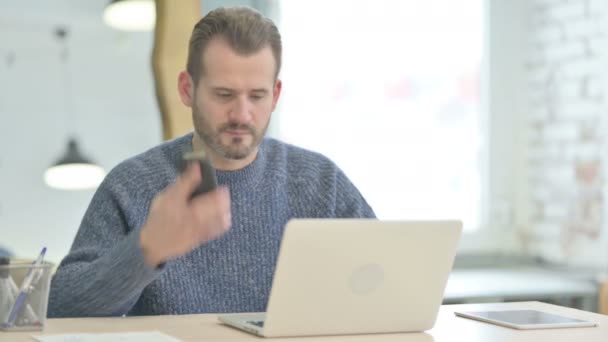 Mature Adult Man Talking Phone While Using Laptop — 图库视频影像