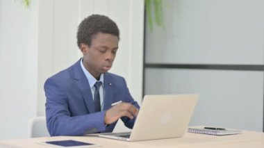 Afrikalı İşadamı dizüstü bilgisayarla uğraşırken baş ağrısı çekiyor