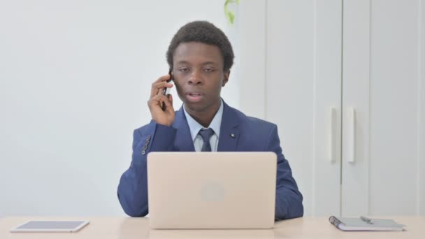 Young African Businessman Talking Phone Using Laptop — Video Stock