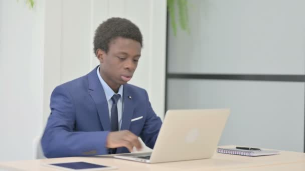 African Businessman Having Back Pain While Using Laptop — Stock Video