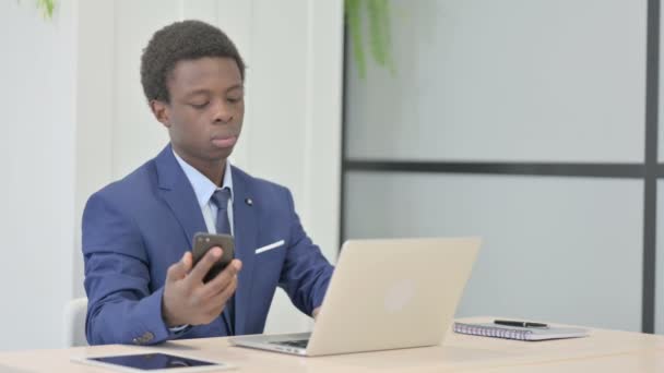 Uomo Affari Africano Che Utilizza Smartphone Durante Utilizzo Del Computer — Video Stock