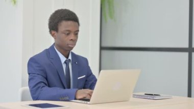 Thumbs Down by African Businessman Working on Laptop