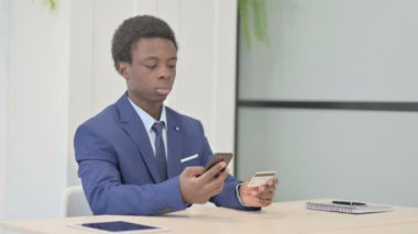 African Businessman making Successful Online Payment on Smartphone
