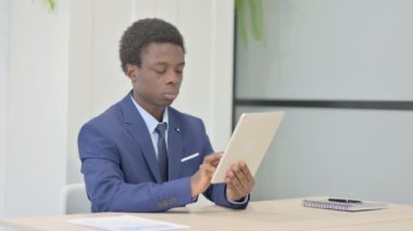 African Businessman using Digital Tablet, Browsing Internet
