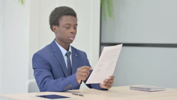 African Businessman Feeling Upset Reading Documents Paperwork — Videoclip de stoc
