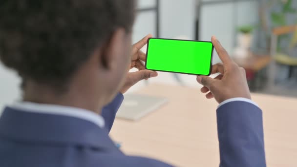 Молодий Африканський Бізнесмен Тримає Горизонтальні Смартфони Зеленим Екраном — стокове відео