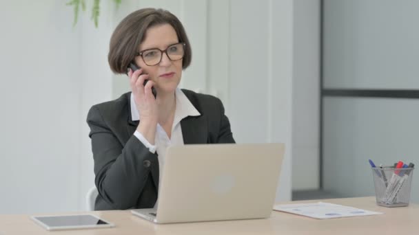 Old Senior Businesswoman Talking Phone While Using Laptop — Stok video