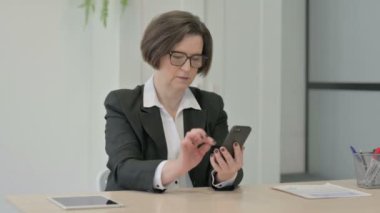 Successful Old Senior Businesswoman Celebrating Win on Smartphone