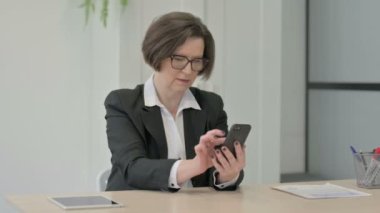 Upset Old Senior Businesswoman Reacting to Loss on Smartphone