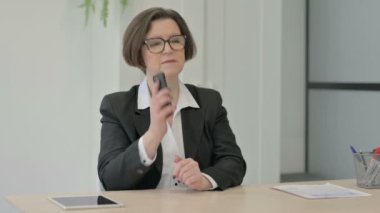Yaşlı kıdemli iş kadını telefonda konuşuyor.