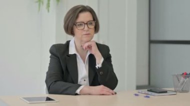 Pensive Old Senior Businesswoman Thinking while Sitting at Work