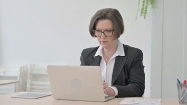 Old Senior Businesswoman Celebrating Online Success on Laptop in Office