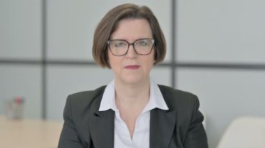 Kamerayı gösteren yaşlı iş kadınının portresi.