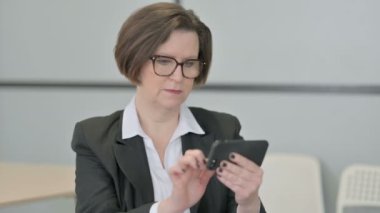 Yaşlı kıdemli iş kadını Smartphone 'daki Kayıplara Tepki Verdi