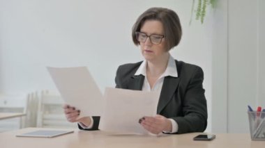 Old Senior Businesswoman Reading Documents in Office, Paperwork
