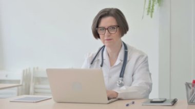 Thumbs Up by Old Senior Doctor Working on Laptop