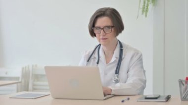 Old Senior Doctor Shaking Head in Rejection while Working on Laptop