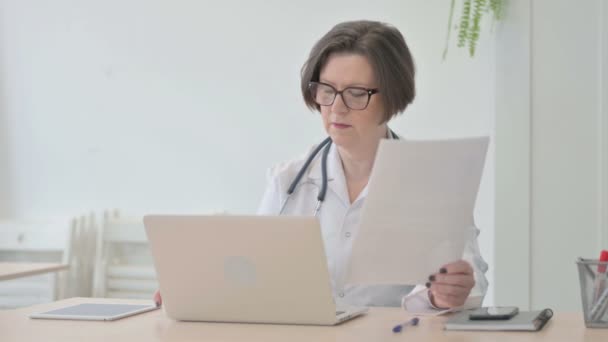Starszy Lekarz Pracujący Nad Dokumentami Laptopem Klinice — Wideo stockowe