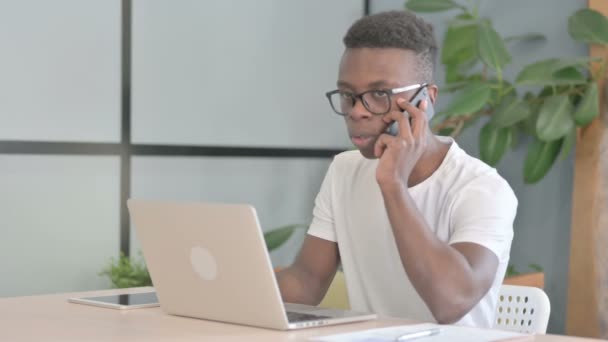 Fiatal Afrikai Férfi Beszél Haraggal Telefonon Munkahelyen — Stock videók