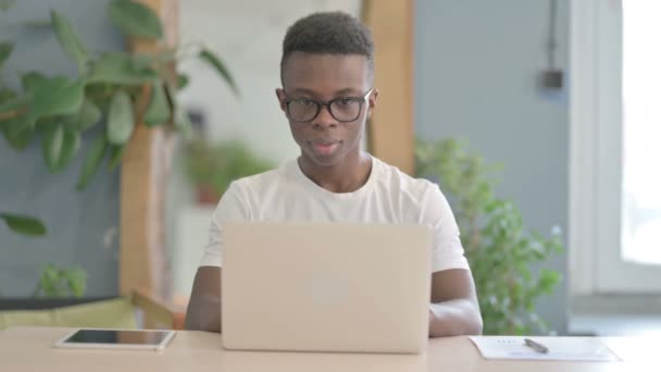African Man Γιορτάζοντας Την Online Επιτυχία Στο Laptop Στο Γραφείο — Αρχείο Βίντεο