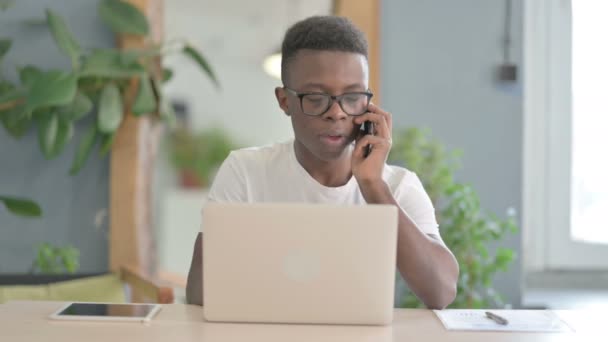不满意的非洲人在工作时在智能手机上愤怒地交谈 — 图库视频影像