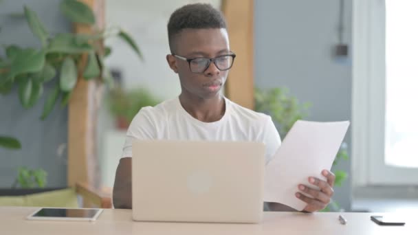 在笔记本电脑和文件上工作的非洲人 — 图库视频影像