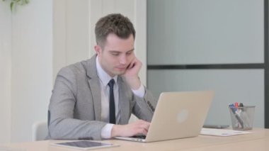 Young Businessman Sleeping while Sitting at Work