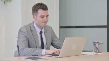 Young Businessman having Toothache while Working on Laptop